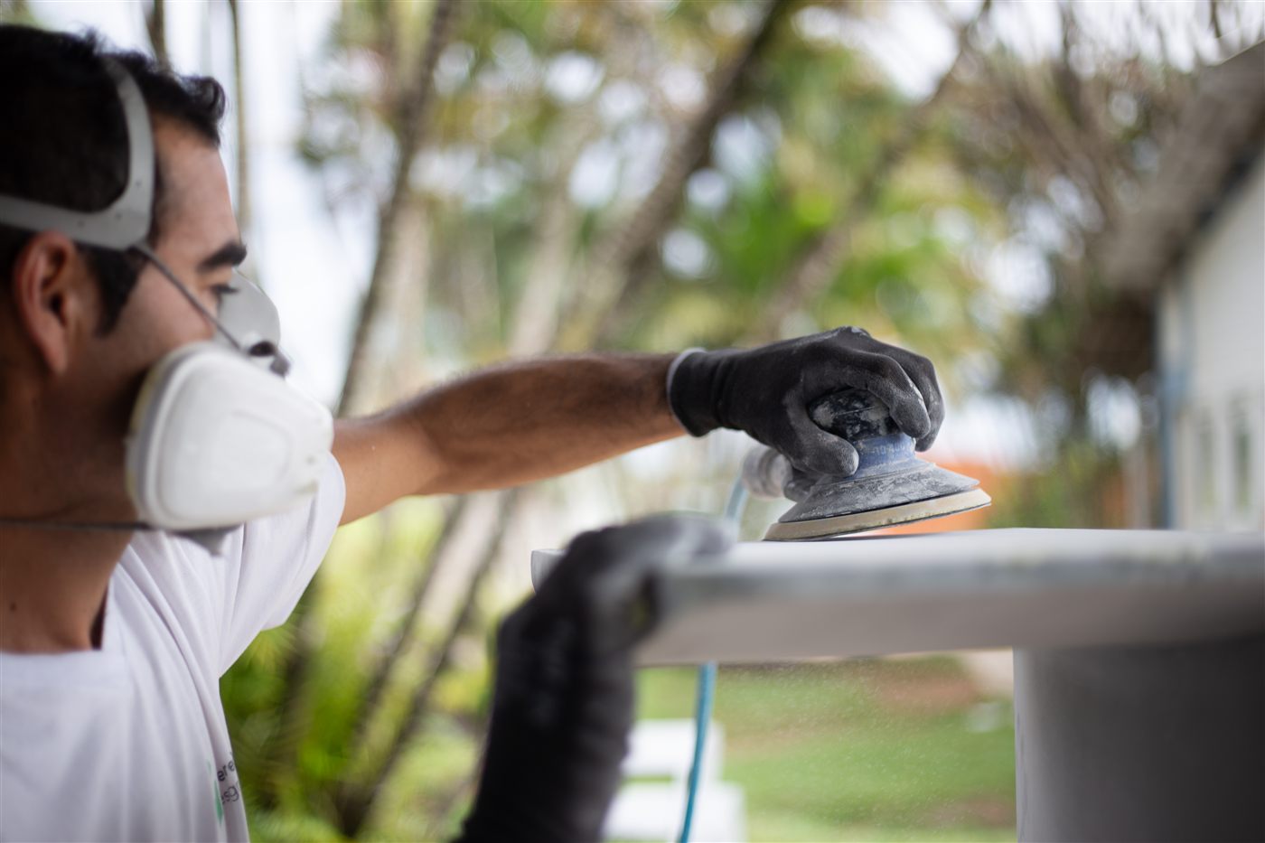 Artesão lixando uma peça Canoa na oficina